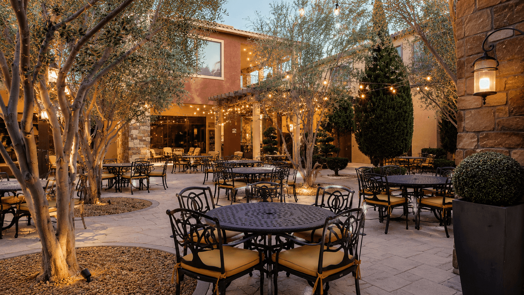 Tuscan Cove courtyard patio with string lights in the evening