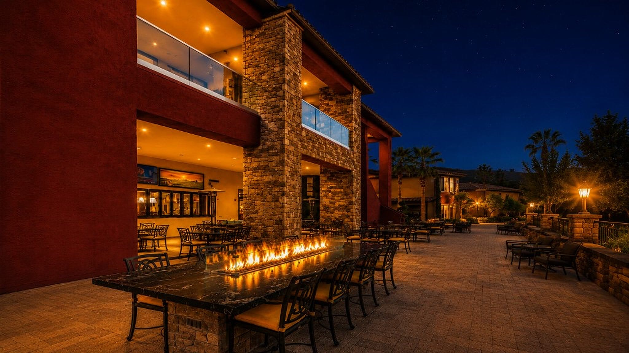 Tuscan Cove patio at night with the long communal fire table glowing